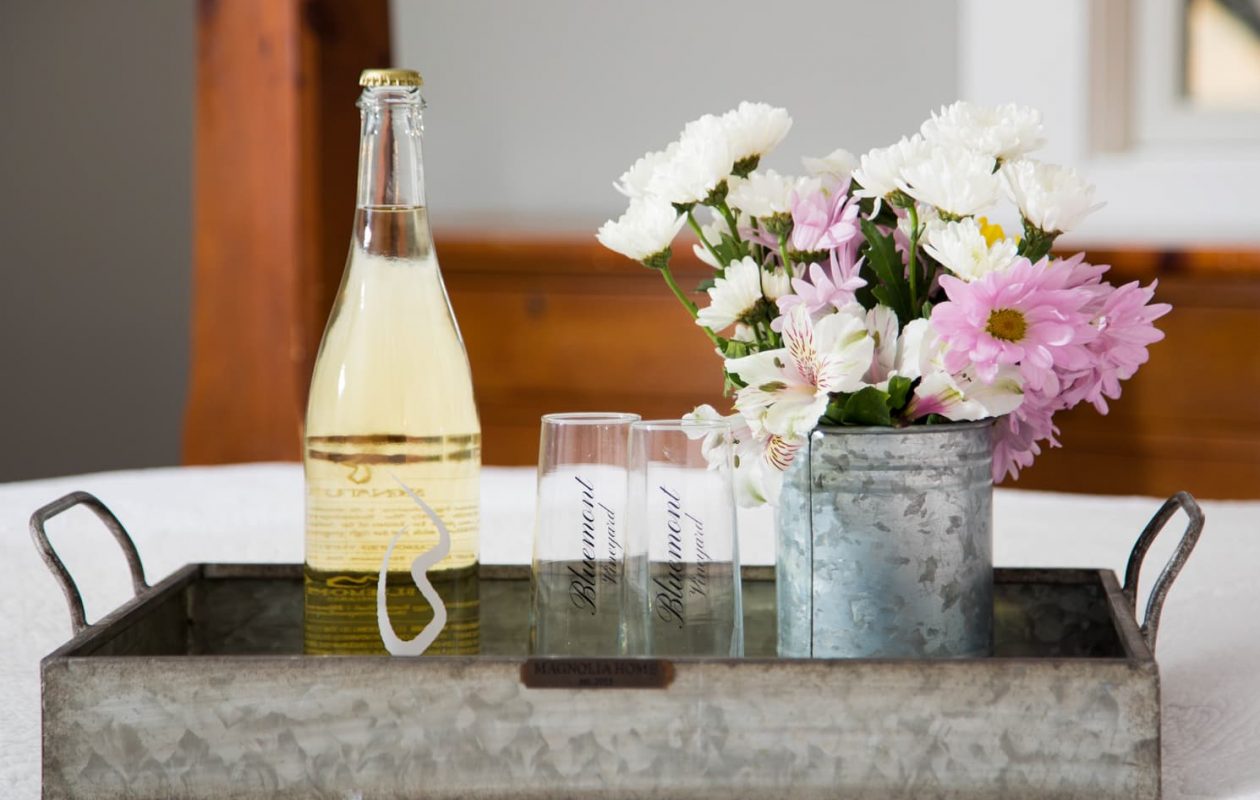 Bluemont Vineyard sparkling wine with two flutes and a bouquet of flowers