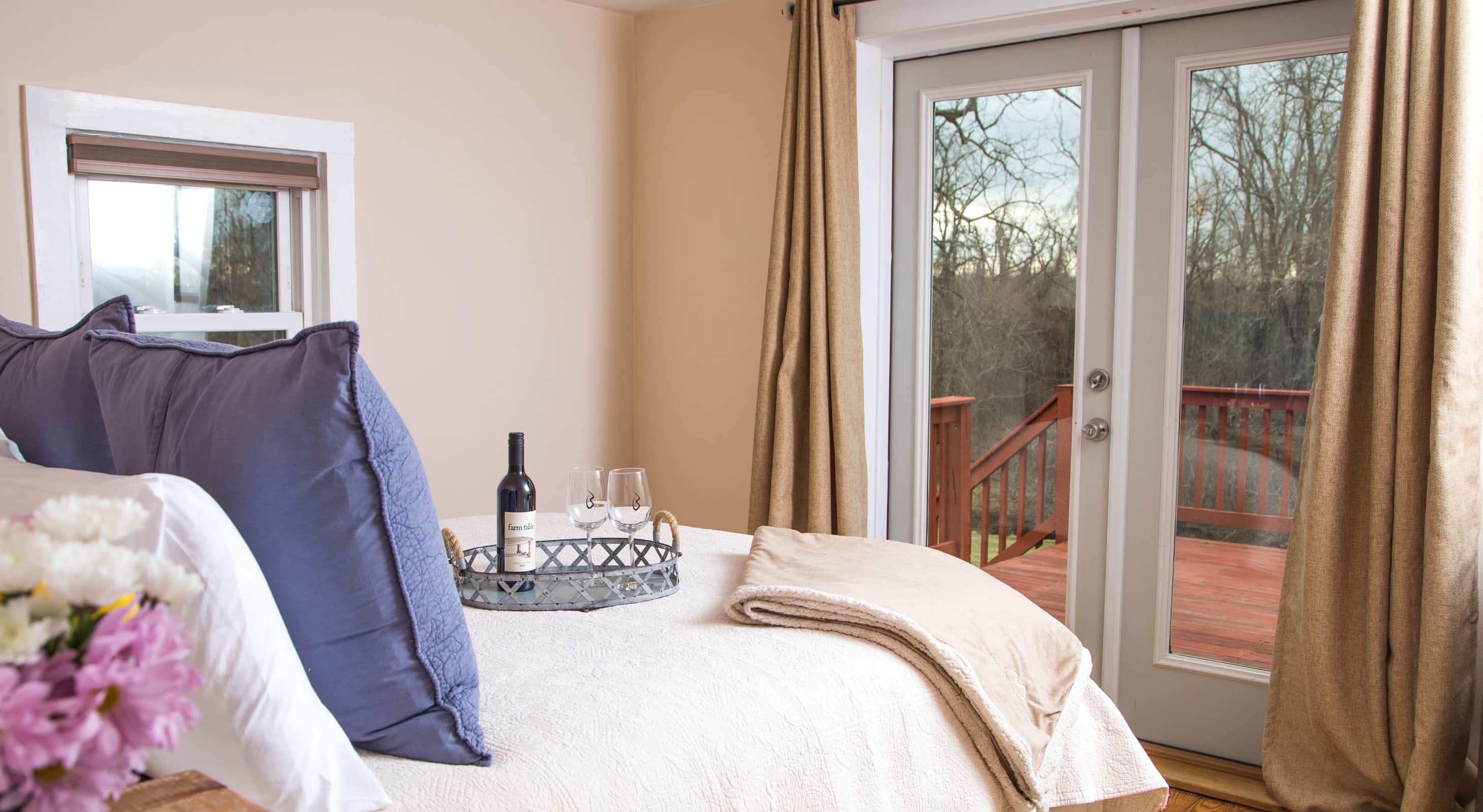 Blue Door Cottage bedroom with double doors to a private balcony