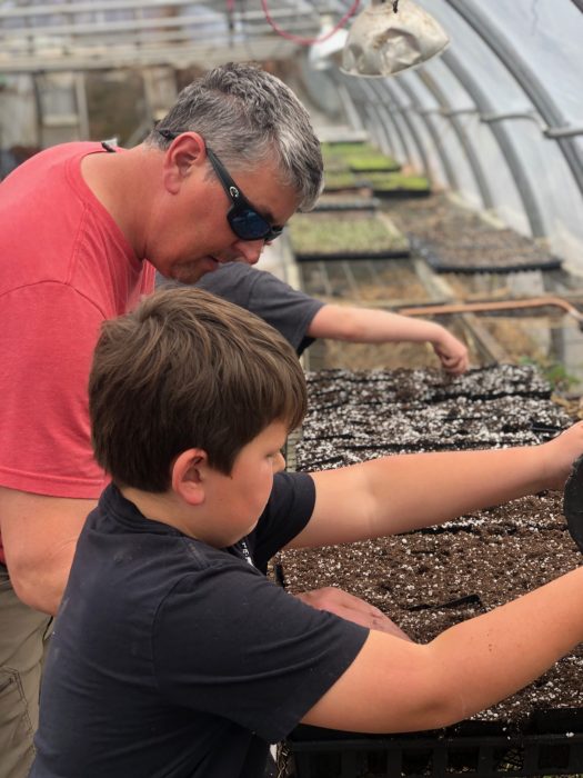 Father and Son planting pumpkin seeds at Dirt farm Brewing Father's Day weekend
