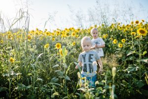boys running through sunflowers