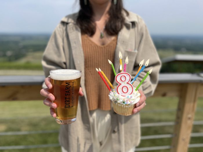 Dirt Farm Brewing guest with pint of craft beer and cupcake to celebrate Dirt Farms eighth birthday!