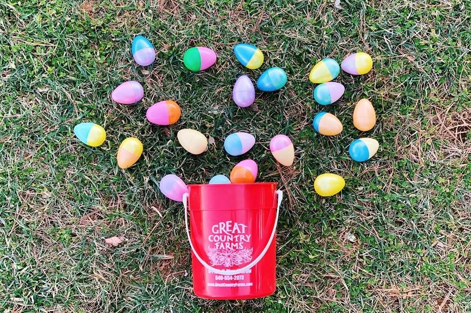 an egg hunt bucket tipped over with eggs sprawled out on the grass