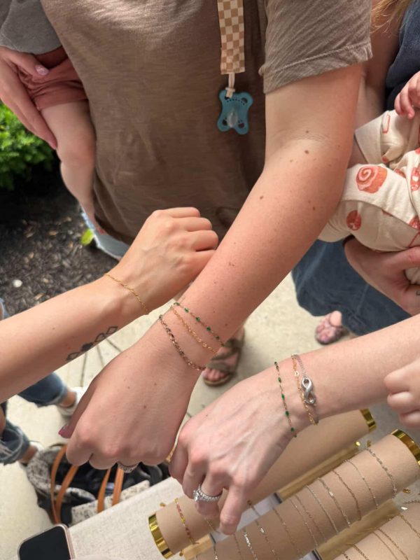 Guests showing off their permanent jewelry at dirt farm brewing in Loudoun county