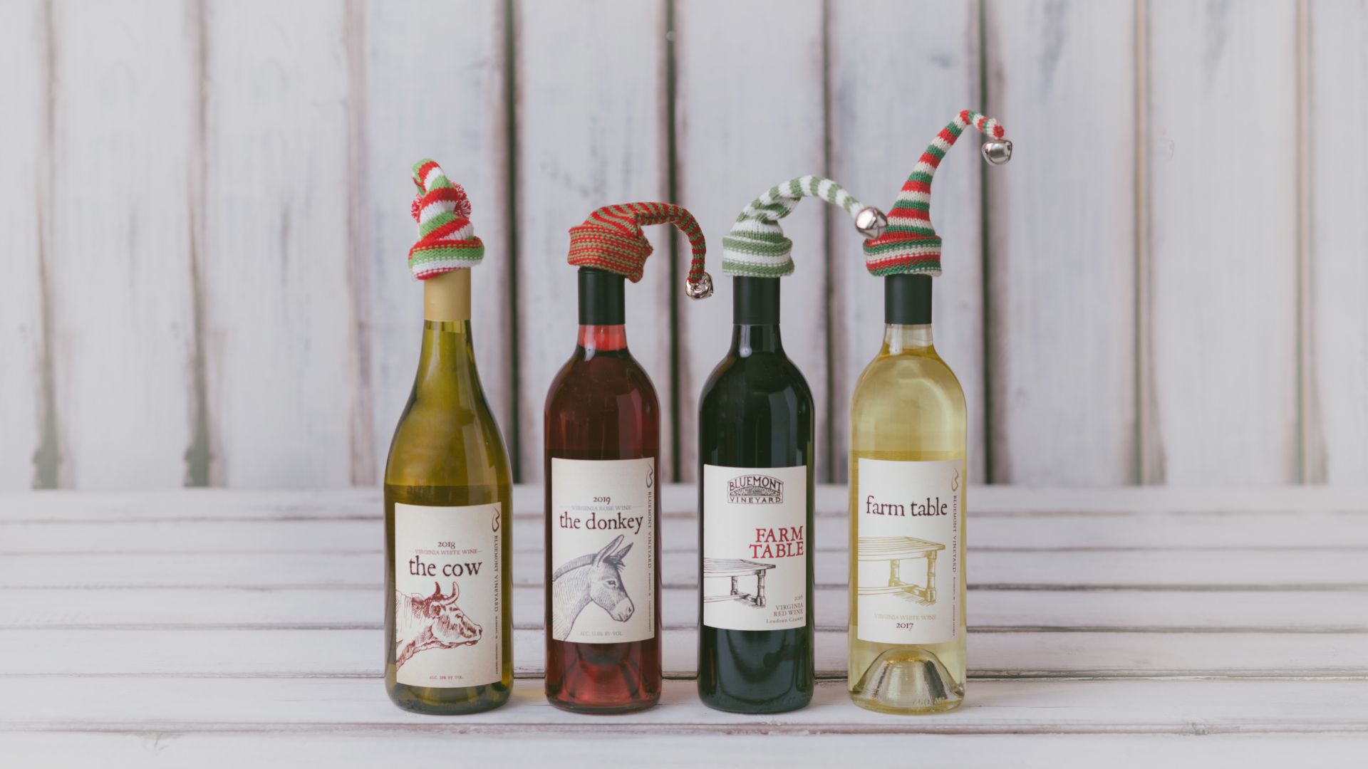 Black Friday and Small Business Saturday promo photo of four wine bottles with holiday hats on top
