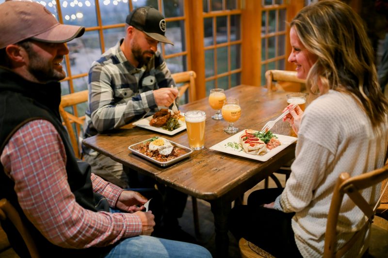 guests enjoying Sunday brunch at dirt farm brewing with a plate of chicken and donuts