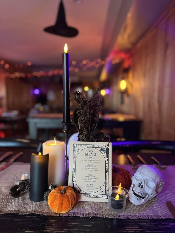 tablescape with skulls, black candles and miniature pumpkins at dirt Farm brewing's Halloween beer dinner in Loudoun county virginia