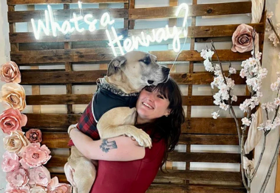 Valentine's Day Pawty main image of girl holding her dog. Henway Hard Cider "What's a Henway" backdrop behind them