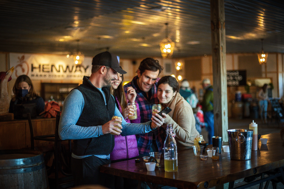 Valentine's Mixology main image of two puples holding drinks. There is a table in front of them with various mixology tools