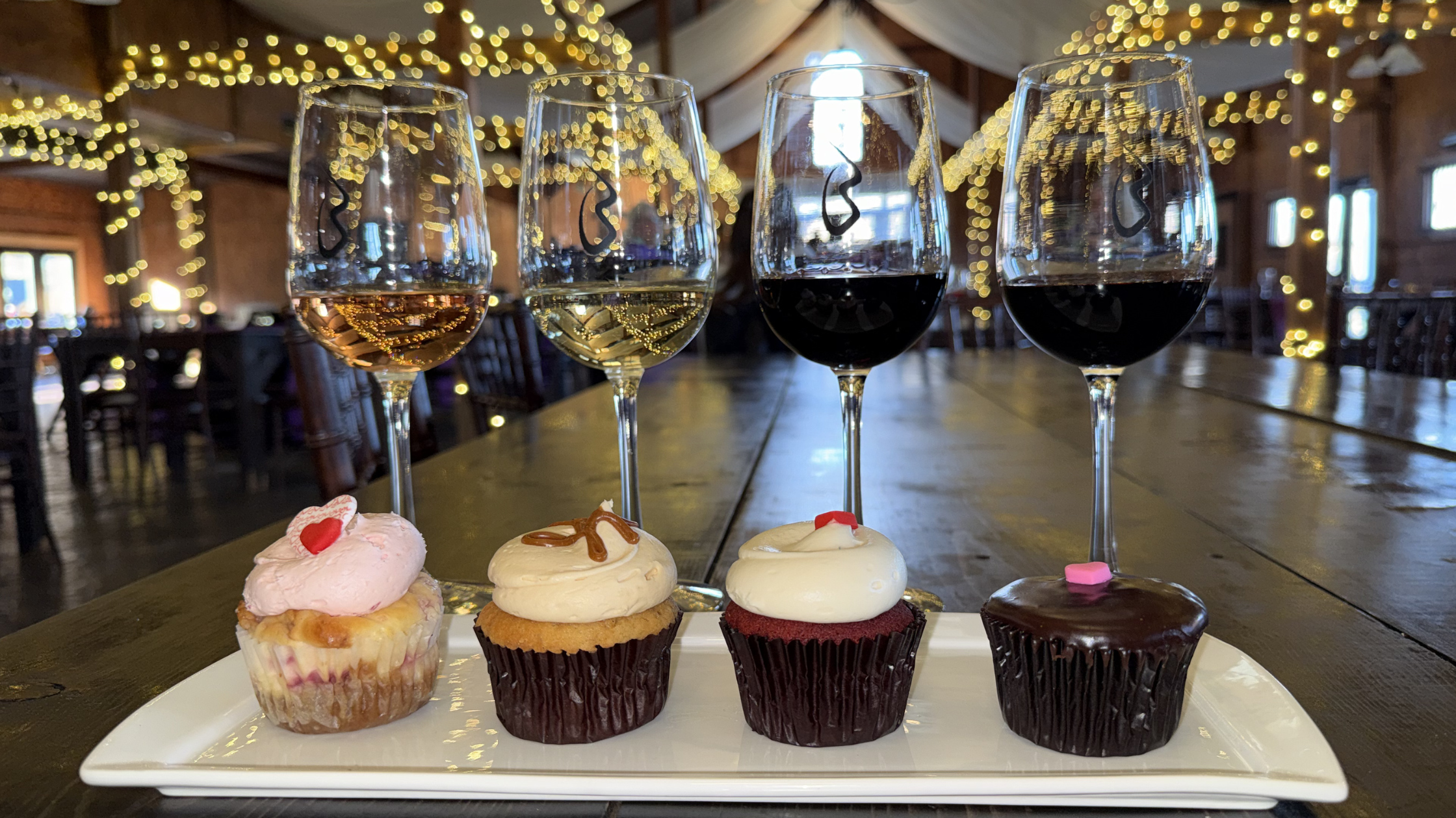 Corks & Cupcakes image. Four winess in glasses behind a plate with four Georgetown Cupcakes on a plate in front
