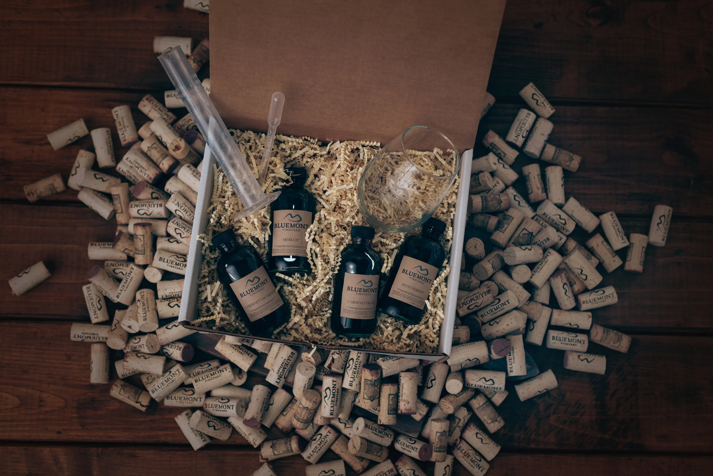 Bordeaux Blending Lab main image of small blending bottles and beakers set inside a box that is surrounded by corks