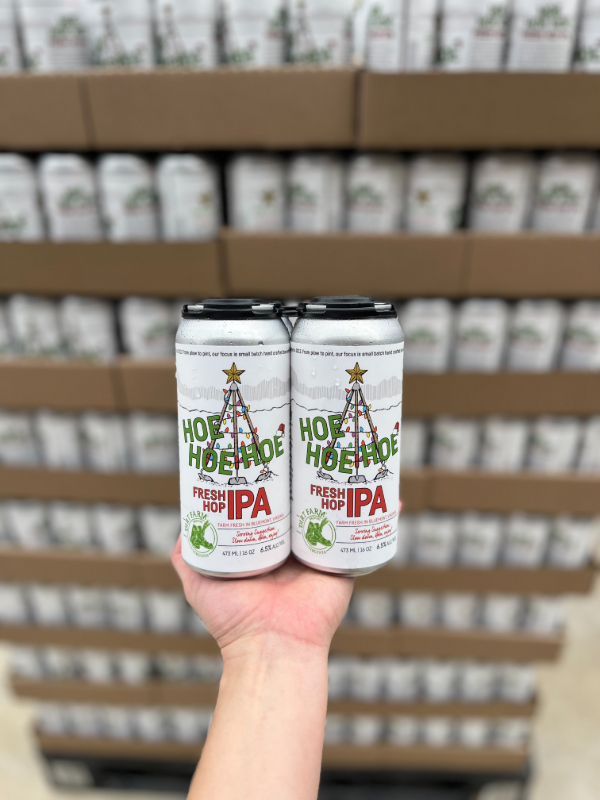 Hoe Hoe Hoe Holiday IPA Release at Dirt Farm. Guest holding a four pack of beer in Loudoun county virginia